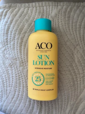 ACO Sun Lotion SPF 25 200ml - Solkräm från ACO med SPF 25 som ger intensiv återfuktning och medelstarkt skydd mot solen. Gul plastflaska med turkos kork, innehåller 200 ml. Lätt att smörja in, vattenresistent och kladdfri formula. Perfekt för dig som vill skydda huden mot UV-strålar.