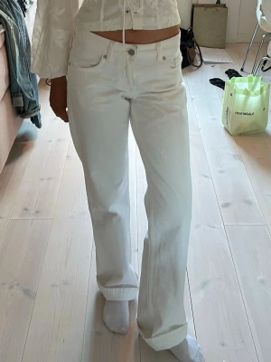 Vita jeans Zara wide leg låg midja - Säljer ett par vita jeans från Zara som sitter lite mer Baggy. Storlek 32 men större i storleken. Säljer för 330 kr då de knappt är använda. Jeansen har klassisk femficksdesign och stängs med knapp och dragkedja. Perfekta för en clean och fräsch look. Materialet är denim i bomull.