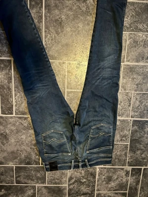 Blå slim fit jeans med kontrastsömmar - Snygga blå replay slim fit jeans med kontrastsömmar, väl använda pris kan diskuteras 