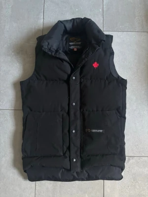 Canada Goose Väst - Säljer nu denna snygga canada goose väst! Den är storlek xxs men passar som en xs - skick är 9/10 - självklart är den äkta - hör av dig vid minsta fundering!