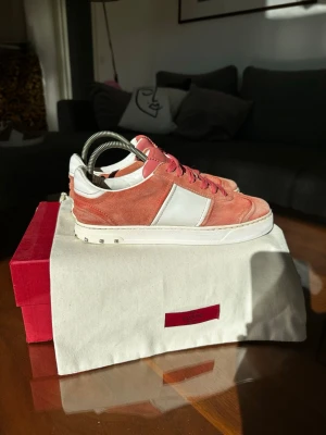Valentino Garavani rosa flycrews - Snygga sneakers från Valentino Garavani i rosa mocka med vita detaljer och vita sulor. Skorna har rosa skosnören och en klassisk låg silhuett. Perfekta för dig som vill ha något unikt och trendigt i garderoben. Alla nitar sitter kvar. Nypris ~6000kr säljs inte längre. Lite helldrag. Obs inget originellt medföljer.
