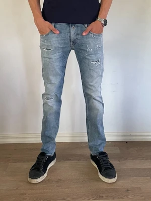 Replay Jeans - Säljer ett par riktigt snygga replay jeans med  slitningar för endast 499kr!                             Använd ett par gånger men fortfarande i bra skick!                                                              Nypris:1699kr därav väldigt bra erbjudande.             Modell: Slim fit                                                        Om ni har några frågor är det bara att fråga på!