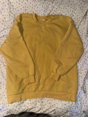 Gul sweatshirt från Gina Tricot XL - Gul sweatshirt från Gina Tricot, basically basics-kollektionen. Klassisk modell med rund halsringning, ribbade muddar vid ärmslut och nederkant. Perfekt för en avslappnad och trendig stil.