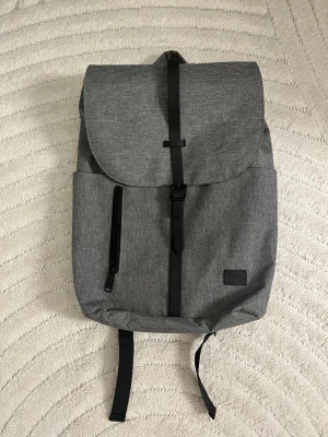 Grå ryggsäck - Säljer då den inte kommer till användning. Den är köpt från Zalando. Jag har 2 stycken. Den är använd max 2 gånger! Den rymmer även min MacBook dator! 