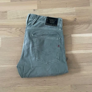 Replay anbass  - Säljer ett par schysta replayjeans i färgen grå med en liten touch av grön. Dem är i fint skick och knapps använda. Storlek är 32W 32L och mått är 100cm L 42cm M. 