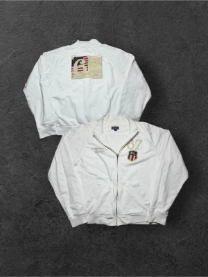 Vintage Ralph Lauren ”RL 67” zip up tröja/kofta - herr strl M, oversized  - Säljer en vintage Ralph Lauren zip up tröja eller kofta i vit färg i storlek M med oversized fit. Två broderingar på bröstkorgen samt stor Ralph Lauren 67 flagga på ryggen.  👕 Märke: Ralph Lauren 📏 Storlek: M, oversized fit 🎨 Färg: Vit 🧵 Material: 100% bomull 📐 Mått: 69 cm lång, 63 cm bred 📌 Skick: Mycket bra skick (se bilder)  💬 Hör av dig vid frågor 💰 Pris kan diskuteras vid snabb affär 📦 Skickas inom 24 timmar