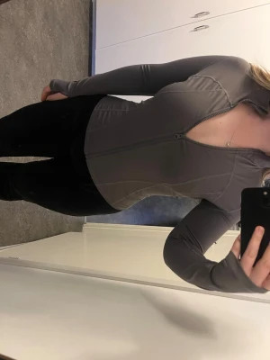 Grå träningsjacka  - Säljer en grå långärmad ziptröja med hög krage och figurnära passform. Tröjan har tumhål i ärmsluten och är tillverkad i ett stretchigt material. Den första bilden visar den riktiga färgen🩶 strl är L men passar också M