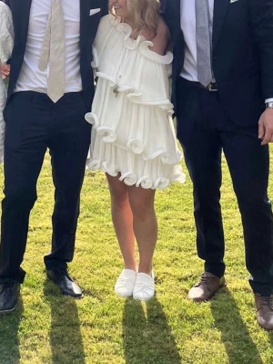 Vit oneshoulder volangklänning - En vit volangklänning från nakd!  Köpte på Vinted med prislapp och använd en gång efter de😍 Jag har sytt upp den på längden samt vid ärmen, men det går att sprätta bort☺️ Köpte min för 800 Strlk 38 men passar mig som vanligtvis är 36 