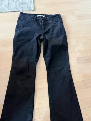 Svarta bootcut jeans 315 shaping - Snygga svarta jeans i modellen 315 Shaping Bootcut med klassisk femficksdesign och utsvängda ben. Jeansen har en smickrande passform och är perfekta för dig som gillar en tidlös look. Materialet är stretchigt för extra komfort.