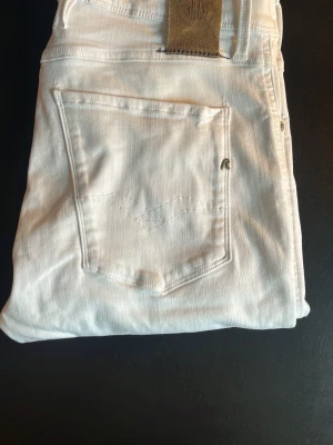 Vita slim fit jeans från Replay - Snygga vita slim fit jeans från Replay med klassisk femficksmodell och dragkedjegylf. Jeansen har en stilren look med diskreta sömmar och Replay-logga på bakfickan. Tillverkade i stretchigt material för extra komfort. Waist 31 length 30