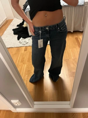 Mörkblå lågmidjade jeans  - Säljer ett par mörkblå baggy jeans med raka ben och låg midja. Helt nya oanvända med prislappen kvar ❤️