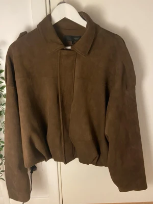 Bomberjacka med mockaeffekt - Helt ny, köpt nyligen och använd en gång bara. Oversized modell. Slutsåld i denna storlek på hemsidan, och bra pris för att vara helt ny! Nypris - 699.