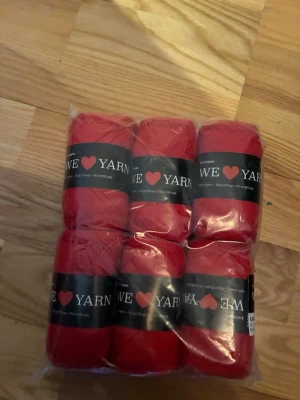 Rött garnpaket från We Love Yarn - Säljer ett paket med sex nystan rött garn från We Love Yarn. Garnet är gjort av 100% bomull och varje nystan väger 50 gram. Perfekt för stickning, virkning eller andra kreativa projekt.