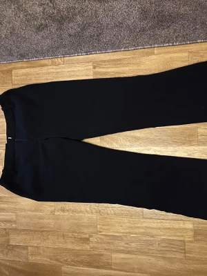 Svarta kostymbyxor från Bik Bok - Snygga svarta kostymbyxor från Bik Bok i storlek 34. Byxorna har raka ben och klassisk passform, perfekta för en stilren look. Materialet känns mjukt och följsamt, vilket gör dem bekväma att bära hela dagen.