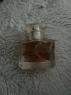 Quelques Notes d'Amour parfym - Elegant parfym från Yves Rocher, Quelques Notes d'Amour. Flaskan är rektangulär i genomskinligt glas med en ljusrosa doftvätska och ett dekorativt lock. Perfekt för dig som gillar romantiska och feminina dofter.