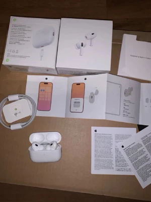 Apple AirPods Pro (vit, in-ear) - Säljer ett par Apple AirPods Pro i vit färg med laddningsetui. Trådlösa in-ear hörlurar med silikontoppar och stilren design. Medföljer laddningskabel, extra öronproppar och originalförpackning samt manualer. Perfekta för musik, samtal och träning.