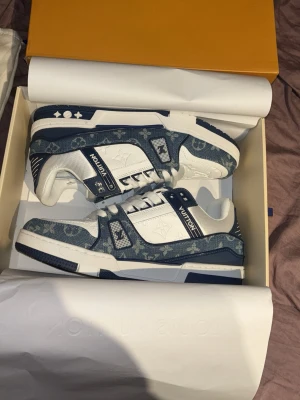 Louis Vuitton blåvita sneakers - Säljer ett par Louis Vuitton sneakers i blått och vitt med klassiskt monogrammönster. Aldrig använda skriv vid frågor 43-44 storlek 