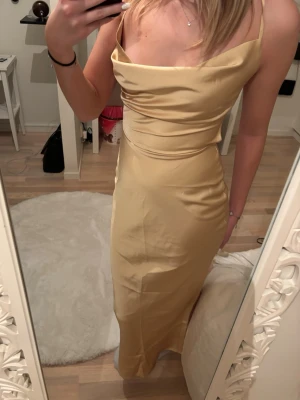 Gul satinklänning - Ljusgul satinklänning med öppen rygg samt liten dragkedja och band baktill från In the Style som ej är använd, perfekt till balen 💗
