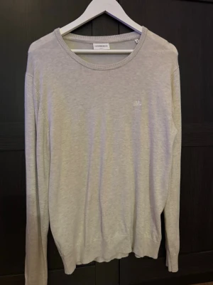 Ljusgrå slim fit tröja Lindbergh - Snygg ljusgrå tröja från Lindbergh i slim fit-modell. Tröjan har rund halsringning, diskret broderad logga på bröstet och ribbade muddar vid ärmslut och nederkant. Perfekt basplagg för en clean och stilren look. (Pris kan diskuteras!)