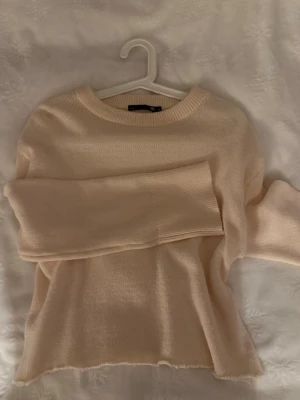 Ljusbeige stickad tröja - Mysig ljusbeige stickad tröja med rund halsringning och långa ärmar. 