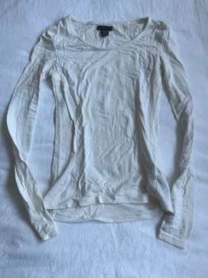Vit långärmad topp från Amisu - En enkel och stilren vit långärmad topp från Amisu. Tillverkad i mjuk bomull med rund halsringning och smal passform. Perfekt att matcha med jeans eller kjol för en clean look.