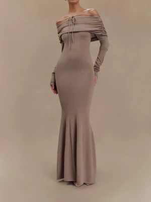 Beige långklänning från Meshki  - Trendig beige långklänning med offshoulder-design och långa ärmar. Klänningen har snörning framtill vid bysten och en figurnära passform som framhäver siluetten. Tillverkad i mjukt stretchigt material, perfekt för dig som gillar stilrena och eleganta looks.
