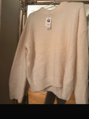 Ljusbeige stickad tröja från Valient - Tröjan har inte prislappen kvar! Mysig ljusbeige stickad tröja från Newhouse med rund halsringning och ribbade muddar vid ärmslut och nederkant. Tröjan har en avslappnad passform och är perfekt för lager på lager. Materialet känns mjukt och skönt mot huden.