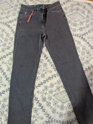 Grå smala jeans från Depot Denim - Snygga grå jeans från Depot Denim med smal passform och klassisk femficksdesign. Jeansen har bälteshällor och dragkedjegylf. Perfekta till vardags och lätta att matcha med olika stilar. Materialet är mjukt och stretchigt för extra komfort.