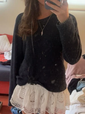 Mörkblå stickad tröja - Mysig mörkblå stickad tröja med rund halsringning och långa ärmar. Tröjan har en enkel, rak passform och ribbstickade muddar vid ärmslut och nederkant. Perfekt att matcha med kjol eller jeans för en avslappnad look.