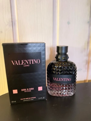 Valentino Uomo Born In Roma Intense - Valentino Uomo Born In Roma Intense är en lyxig parfym i en mörk, diamantmönstrad glasflaska med svart kork. Doften kommer i en elegant svart kartong med rosa detaljer. Flaskan rymmer 100 ml och har en exklusiv och modern design. Inte använd!
