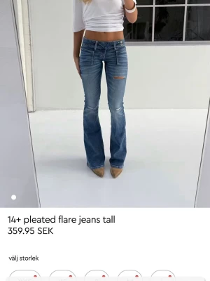 Blåa flare jeans med slitning - Säljer ett par blåa flare jeans med låg midja från gina tricot storlek S Tall. säljer jeansen då de inte kommer till användning längre. pris kan diskuteras