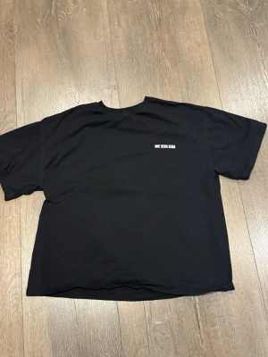 Svart t-shirt NLY MAN - Svart t-shirt med vit text 'QUE SERA SERA' på bröstet. Klassisk rund hals och korta ärmar. T-shirten har en loose passform och är tillverkad i mjuk bomull, perfekt för en avslappnad stil.