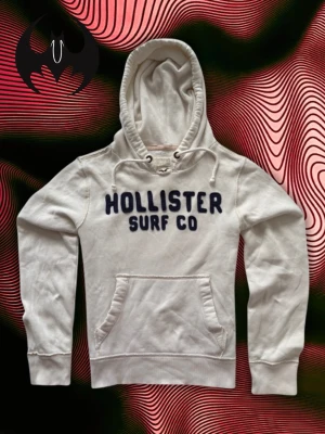 Vit Hollister Hoodie - Vit Hollister hoodie | bra skick, fläck som inte syns med i som är sliten men går att sy | Size M/L | Längd: 65cm Axelbredd: 46cm Armlängd: 70cm | Modell, 178cm 60kg | Lägg endast bud med avsikt att köpa, inga fördröjning!