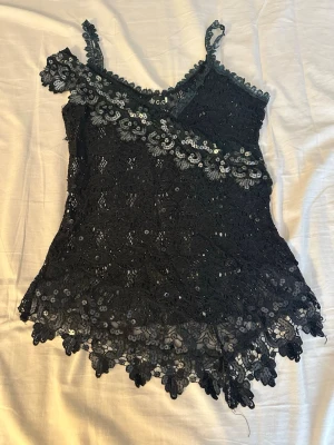 Svart spetslinnetopp med paljetter - Well-worn condition; some sequins may be missing, and there are many loose threads. Tag says M but it fits XS /S