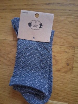 Glittriga silverstrumpor - Snygga glittriga strumpor i silver från Sweettenie Sweden. Strumporna har ett diskret rutmönster och är tillverkade i ett stretchigt syntetmaterial som ger en bekväm passform. Perfekta för att addera lite extra bling till din outfit.