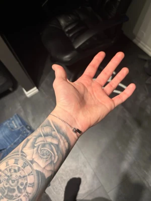 Tunt silver armband från Ysl  - Säljer ett stilrent och tunt armband i silverfärg med en litet märke där det står Ysl. Armbandet har en minimalistisk design och passar perfekt för dig som gillar diskreta accessoarer. Lätt att matcha med andra smycken.