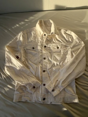 Jeansjackan  - Snygg vit jeansjacka från Zara med klassisk krage, bröstfickor med lock och knappar framtill. Jackan har en stilren look och är perfekt för dig som vill ha en fräsch och trendig stil. Långärmad och i mjukt jeanstyg. Aldrig använt.