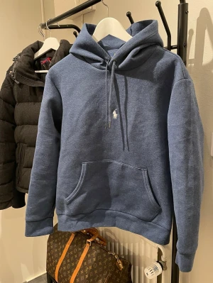 Ralph Lauren hoodie - Snygg blå hoodie från Polo Ralph Lauren med klassisk huva och dragkedja. Lite unikare Ralph lauren hoodie med en lite unikare blå färg. 🔥Bara höra av sig i dm vid frågor och funderingar!🔥(Bild med den på kan visas i dm)‼️