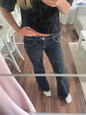 Mörkblå bootcut jeans Gina Tricot - Säljer ett par mörkblå bootcut jeans med vita kontrastsömmar och låg midja. Jeansen är från Gina Tricot och är i storlek 34, de är slutsålda. Använda två gånger.