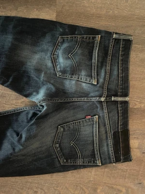 Levi's mörkblå slim jeans - Vintage Levi’s Jens. Jensen är sparsamt använda men har några defekter! Jensen är uppsydda men inget men ser tydligt. Taggen har tyvärr fallit av där med priset. Skriv vid mer funderingar! 