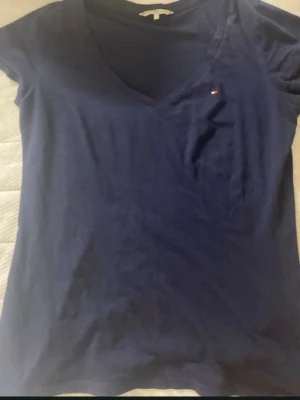 Tommy hilfigher Tshirt med en liten slit - En marinblå tommy hilfigher tshirt med en vringad hals