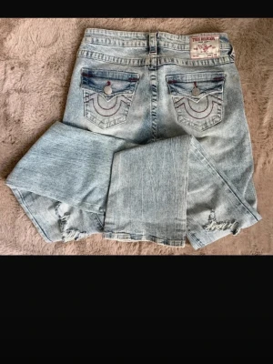 Bootcut true religion jeans  - Skit snygga true religion jeans i ljusblå med hål.Köptes på Raglady för 1500kr använt fåtal gånger dem är i storlek 26.