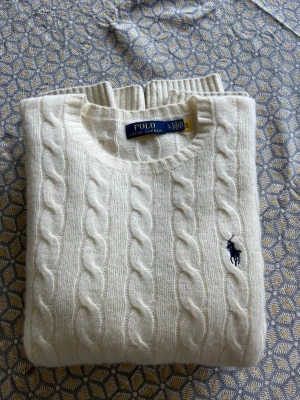 Kabelstickad kaschmirtröja Ralph Lauren - Eftertraktad kabelstickad tröja i kaschmir från Polo Ralph Lauren. Endast använd ett fåtal gånger, säljes för att jag tröttnat på den. Tröjan är i storlek L, men ganska liten i passformen så den sitter som en M. Nypris ligger runt 2700kr. Skriv gärna vid frågor. 
