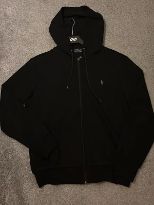 Ralph Lauren zip hoodie - Hej! Säljer en svart RL zip då den inte passar längre. Står storlek S men skulle säga att den snarare passar XS. Hör av dig om du har några förändringar!!