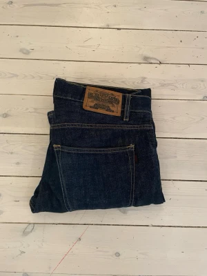 Mörkblå Crocker jeans 312 Regular - Säljer ett par mörkblå jeans från Crocker, modell 312 Regular. Klassisk design  med kontrastsömmar och läderpatch bak i midjan. Jeansen har rak passform och är tillverkade i slitstarkt denimtyg. Perfekta för en avslappnad och tidlös stil.