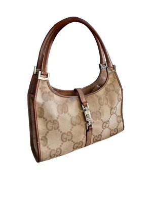 Beige GG monogram handväska Gucci - Modell: Klassisk Jackie Bag (piston-stängning) Serienummer: 002-1068 001998 (se bild för autenticitet) Material: Jumbo GG Monogram Canvas med läderdetaljer Färg: Klassisk Gucci-beige/brun Beskrivning  Säljer en ikonisk Gucci Jackie hobo i den eftertraktade "Jumbo GG"-canvasen. Denna tidlösa modell har burits av stilikoner i decennier och är just nu en av de mest trendiga vintageväskorna på marknaden. Perfekt storlek för vardagsbruk med den karaktäristiska "piston"-stängningen i silverfärgad meta