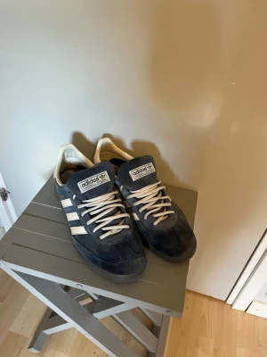 Adidas Spezial  - Mörkblå Adidas Handball Spezial sneakers med klassiska vita ränder på sidorna och vita skosnören. Ovandelen är i mocka och insidan har Adidas-logga. Snygg retrostil med låg profil och bekväm passform. Kartong medföljer och där i ligger blåa snören ifall man skulle vilja byta till det🙌