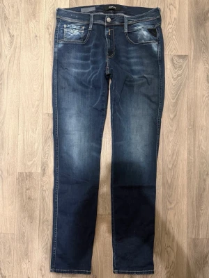 Replay Anbass Hyperflex Jeans Blå W33 - Slim Fit - Replay Anbass Hyperflex blå jeans i stretchig Hyperflex denim med slim fit passform som sitter snyggt och bekvämt och funkar till allt, storlek uppskattad W33/L okänd (innerlapp avklippt), midja 43 cm, ytterbenslängd 109 cm, benöppning 16,5 cm, modellen är 185cm & väger 65kg, i fint skick.