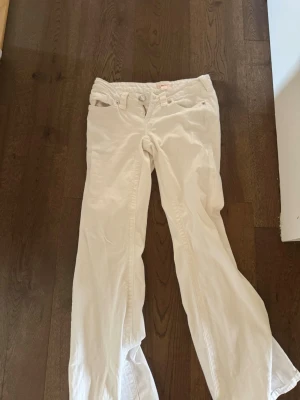 Trendiga vita rundat jeans - Snygga vita jeans med bootcut-modell och broderade bakfickor. Jeansen har klassisk femficksdesign, låg midja och stängs med dragkedja och knapp. Perfekta för en trendig och fräsch look. Helt nya utan prislapp och säljer då dom inte passade mig men redan dragit bort prislappen.