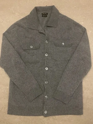 Grå Kashmir wool overshirt från Massimo Dutti - Stilren grå overshirt från Massimo Dutti i mjuk ull- och kashmirblandning. Klassisk krage, knäppning framtill och två bröstfickor med knapp. Perfekt lager på lager-plagg och snygga detaljer. Riktig skön och varm overshirt som har en slim passform till dig som har XS,  skriv vid funderingar🤩🤩